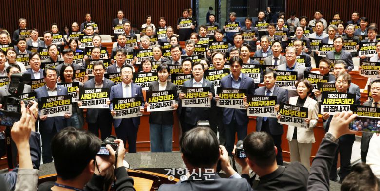 더불어민주당 의원들이 지난 5월 4일 국회에서 열린 긴급 의원총회에서 “사법쿠데타 끝장내자”라고 쓰인 손팻말을 들고 대법원을 규탄하고 있다. 한수빈 기자