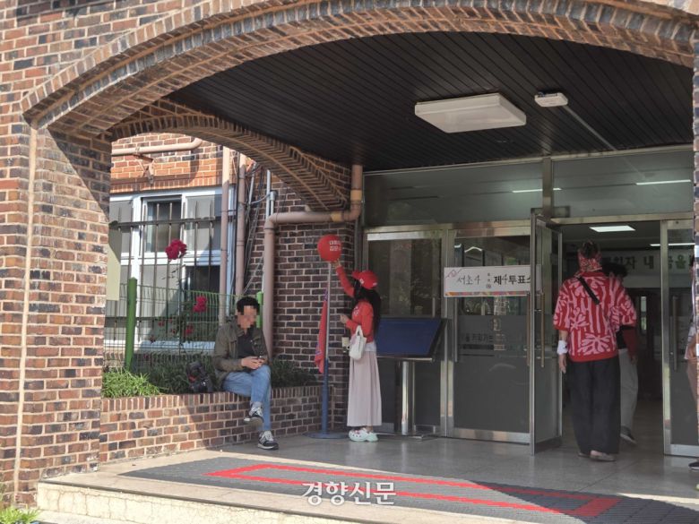 빨간색 옷을 입은 여성이 3일 서울 서초구 윤석열 전 대통령 사저 인근 투표소에서 ‘대통령 김문수’라고 적힌 풍선을 두고 있다. 우혜림 기자