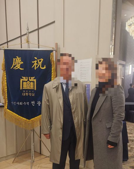 손효숙 리박스쿨 대표가 운영하는 방과후학교 위탁기업 ‘글로리사회적협동조합’의 감사이자 KHHC의 이사인 A씨(오른쪽)가 대통령실 축기를 배경으로 서 있다. KHHC 홈페이지 갈무리