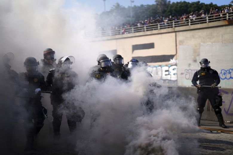 8일(현지시간) 로스앤젤레스 시내 메트로폴리탄 구치소 인근 101번 고속도로에서 연기 너머로 경찰들의 모습이 보이고 있다. AP연합뉴스