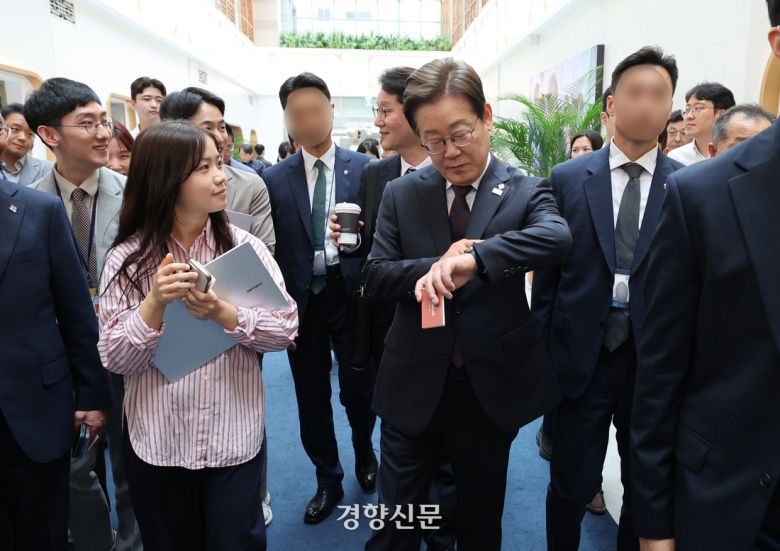 이재명 대통령이 10일 용산 대통령실 직원식당에서 식사를 마친 뒤 집무실로 돌아가며 취재진과 인사하다 시계를 들여다보고 있다. 대통령실사진기자단