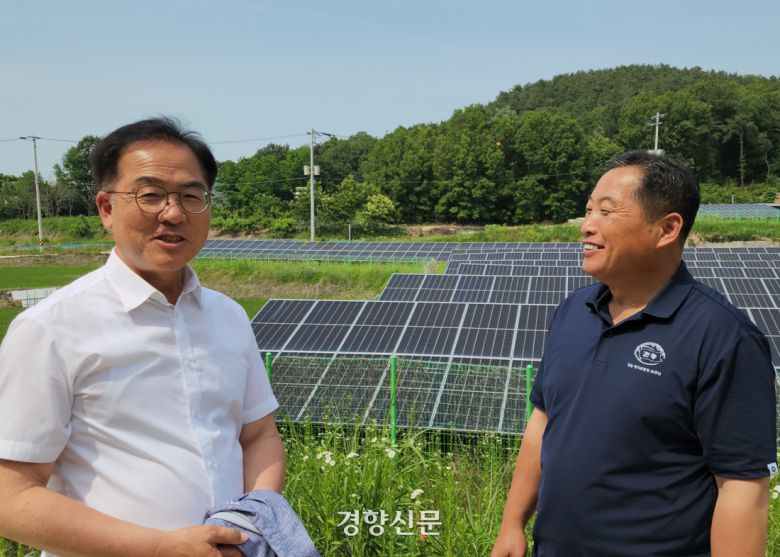 문재인 정부 시절 대통령실 농해수비서관을 지낸 최재관 더불어민주당 여주시·양평군 지역위원장(왼쪽)과 전주영 이장이 지난 6월 5일 구양리 마을 소유 농지에 설치된 태양광 패널 앞에서 이야기를 나누고 있다. 이재덕 기자