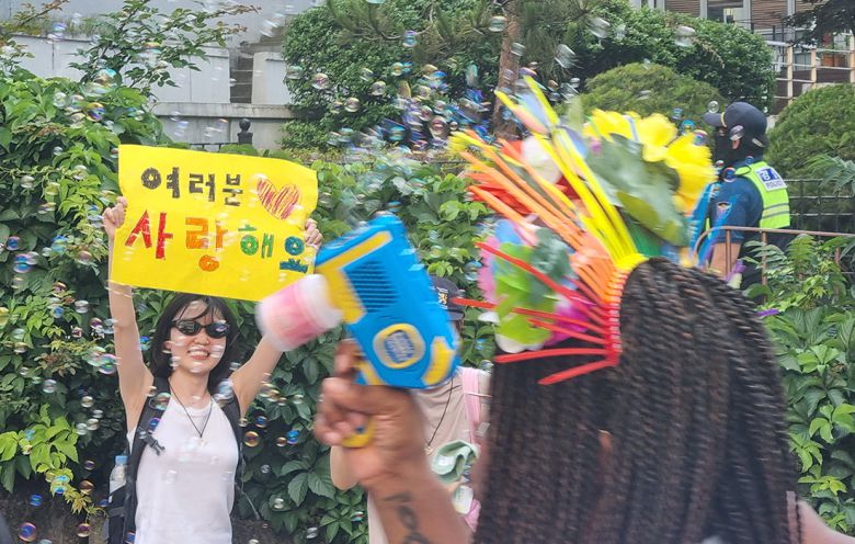 이정민씨(24)가 서울 중구 인권위원회 인근에서 노란 도화지에 손글씨로 ‘여러분 사랑해요’라고 쓴 팻말을 들고 “사랑한다”고 외치고 있다.  강한들 기자