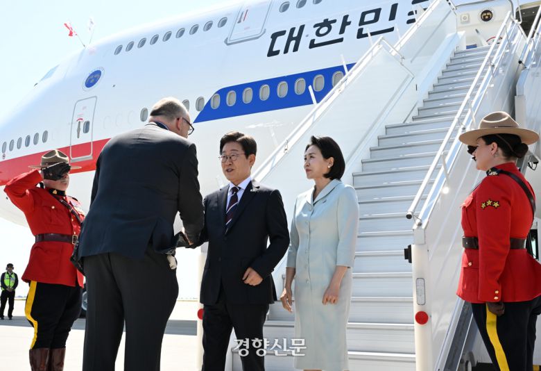 이재명 대통령과 김혜경 여사가 16일 (현지시간)  캘거리공항에 도착해  세바스띠엥 까리에르(왼쪽) 캐나다 외교부 의전장과 악수를 하고 있다. 김창길 기자