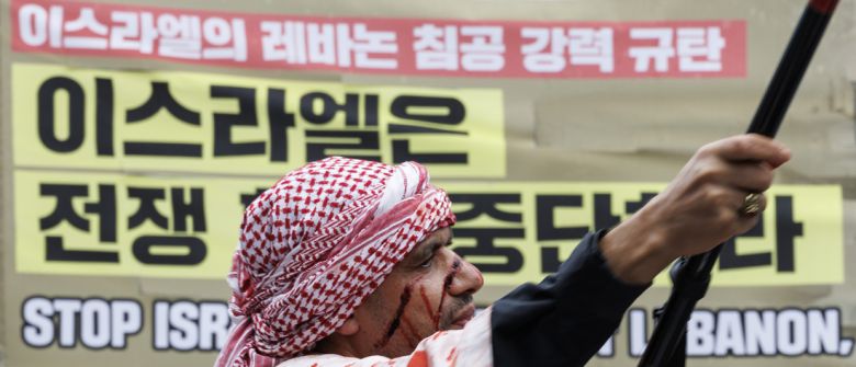 지난해 10월6일 서울 종로구에서 열린 ‘가자지구 학살 1년, 10·6 국제 행동의 날’에 참가한 한 참석자가 팔레스타인 깃발을 흔들며 전쟁 중단 촉구 퍼포먼스를 하고 있다. 연합뉴스