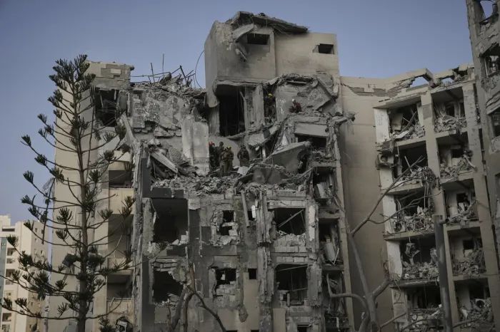 24일(현지시간), 이란의 미사일 공격으로 여러 명이 사망한 이스라엘 베르셰바에서, 이스라엘 군 병사들과 구조대가 파괴된 주거 건물 잔해 속에서 생존자를 수색하고 있다. AP연합뉴스