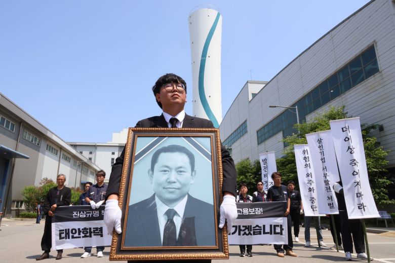 태안화력발전소에서 작업하다 숨진 재하청 비정규직 노동자 고(故) 김충현 씨의 영결식이 18일 오전 충남 태안군 태안화력발전소에서 엄수되고 있다. 김영훈 한전KPS 비정규직지회 지회장이 김충현씨 영정 사진을 들고 있다. 연합뉴스