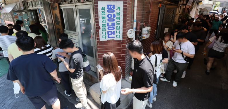 무더위가 시작될 때면 유명 평양냉면집 앞은 늘 인파들로 북적인다.  연합뉴스