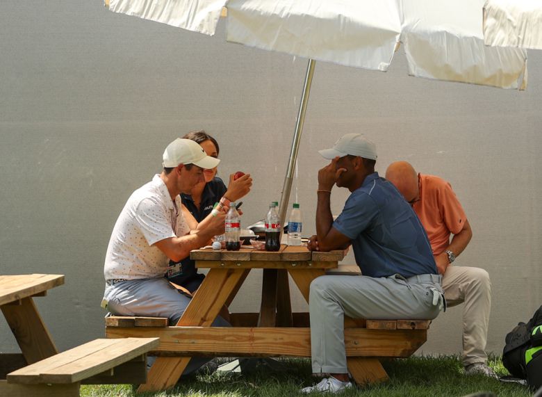 로리 매킬로이, 타이거 우즈가 골프장 파라솔에서 음식을 먹고 있다. 게티이미지