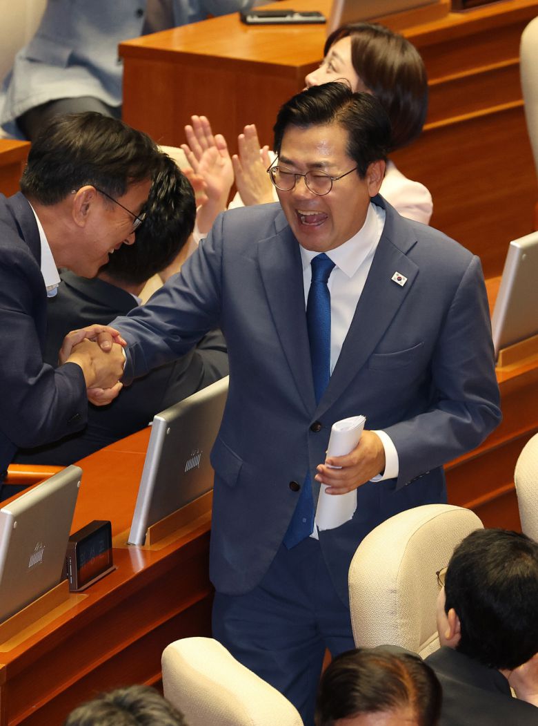 손 꼭 잡고 박찬대 더불어민주당 의원이 10일 국회 본회의장에서 동료 의원들과 인사하고 있다. 연합뉴스