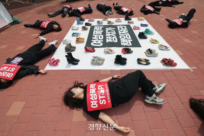 서울여성회 페미니스트 대학생연합동아리 회원들이 지난 4월27일 서울 마포구 홍대입구역 앞에서 열린 ‘2025 대선, 여성폭력 해결! 나중은 없다!’ 캠페인에서 여성폭력 희생자들을 상징하는 신발을 놓고  다이-인(Die-in) 퍼포먼스를 하고 있다. 성동훈 기자
