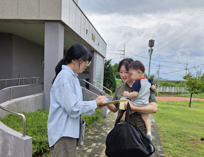 충북 증평군이 시행 중인 ‘온(ON)돌봄 여권 배송 서비스’를 신청한 영·유아 양육가정이 공무원으로부터 여권을 받고 있다. 증평군 제공.