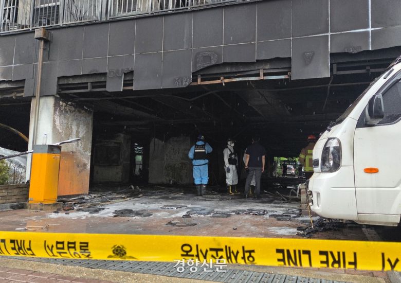 18일 경기 광명시 소하동 A아파트 앞에 설치된 폴리스 라인 뒤로 경찰과 소방 등 관련기관 관계자들이 화재 원인을 조사 중이다. 김태희기자