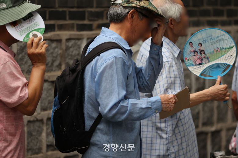 연일 폭염이 계속된 5일 서울 종로구 탑골공원 인근 무료 급식소에서 어르신들이 대기하며 부채질하고 있다. 조태형 기자
