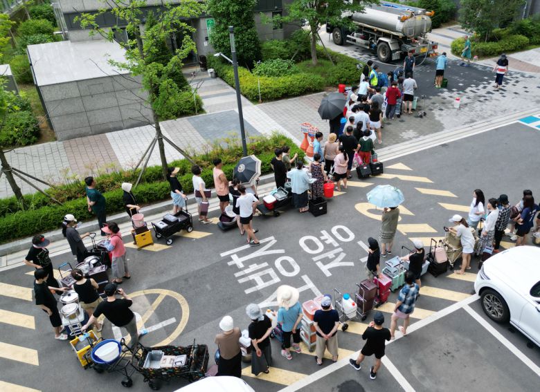 이틀째 단수가 이어지고 있는 울산시 울주군 언양읍 한 아파트 주민들이 21일 살수차에서 물을 받아 가기 위해 줄을 서 있다. 울산시 상수도사업본부에 따르면 지난 19일 내린 호우로 상수도 송수관로가 파손된 영향으로 지난 20일 오전부터 울주군 6개 읍·면 지역에 수돗물 공급이 중단됐다. 연합뉴스