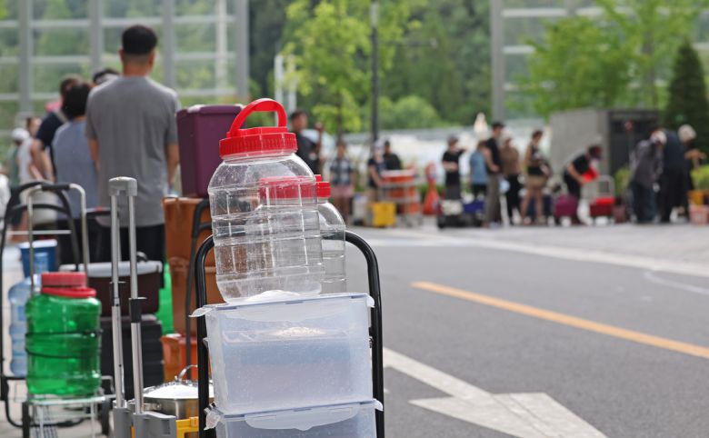 단수가 이어지고 있는 울산시 울주군 언양읍 한 아파트 주민들이 지난 21일 살수차에서 물을 받기 위해 각종 통과 카트를 들고 줄을 서 있다. 연합뉴스