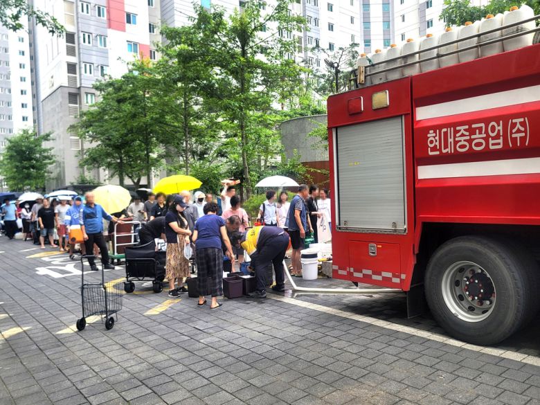 단수가 이어지고 있는 울산시 울주군 언양읍 한 아파트 주민들이 지난 21일 기업체 사내 소방차가 공급하는 생활용수를 받으려고 줄지어 서 있다. 연합뉴스