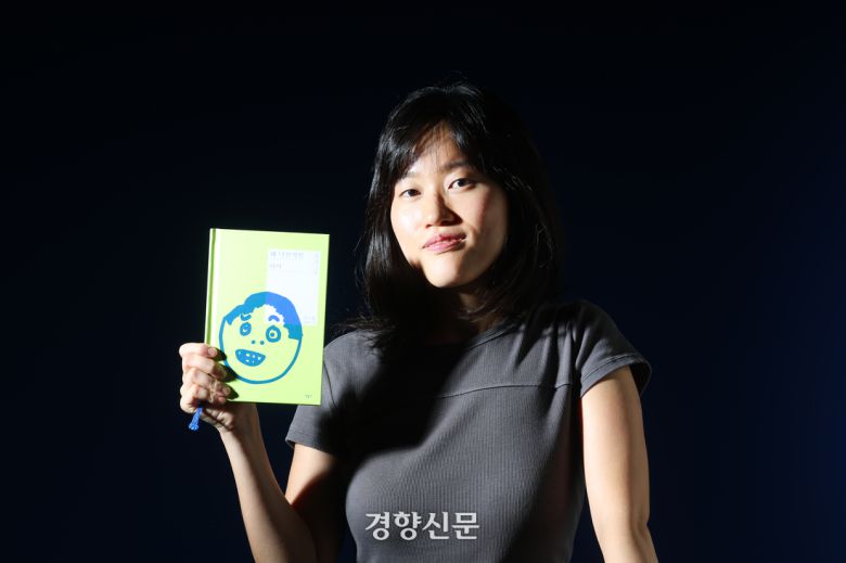 소설 <꽤 낙천적인 아이>의 저자 원소윤씨가 28일 인터뷰에 앞서 경향신문 스튜디오에서 책을 들고 포즈를 취하고 있다. 정지윤 선임기자