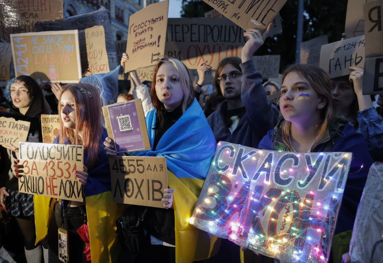 우크라이나 시민들이 골판지에 구호를 쓴 팻말을 들고 있다. 한 시민은 골판지에 전구를 붙였다. EPA연합뉴스
