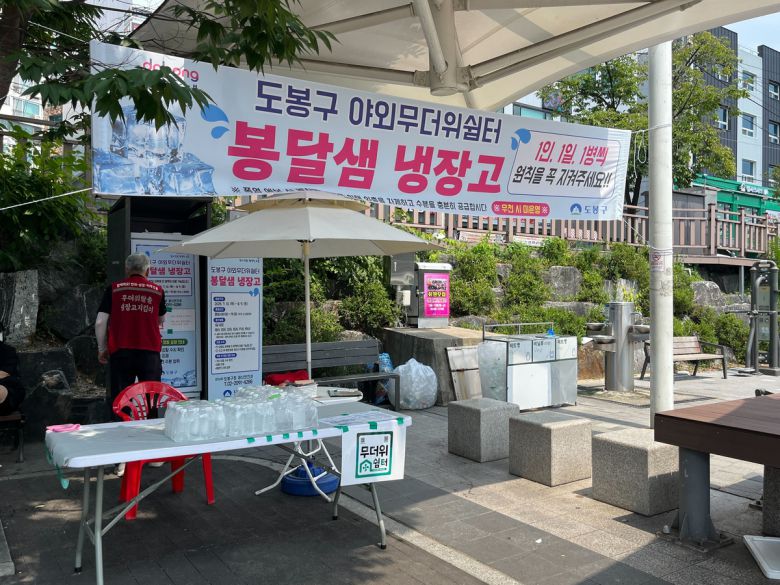 서울 도봉구의 한 야외무더위쉼터에 생수병을 배포하는 ‘봉달샘 냉장고’가 설치돼 있다. 쉼터 오른편에는 아리수 음수대가 있다. 여성환경연대 제공