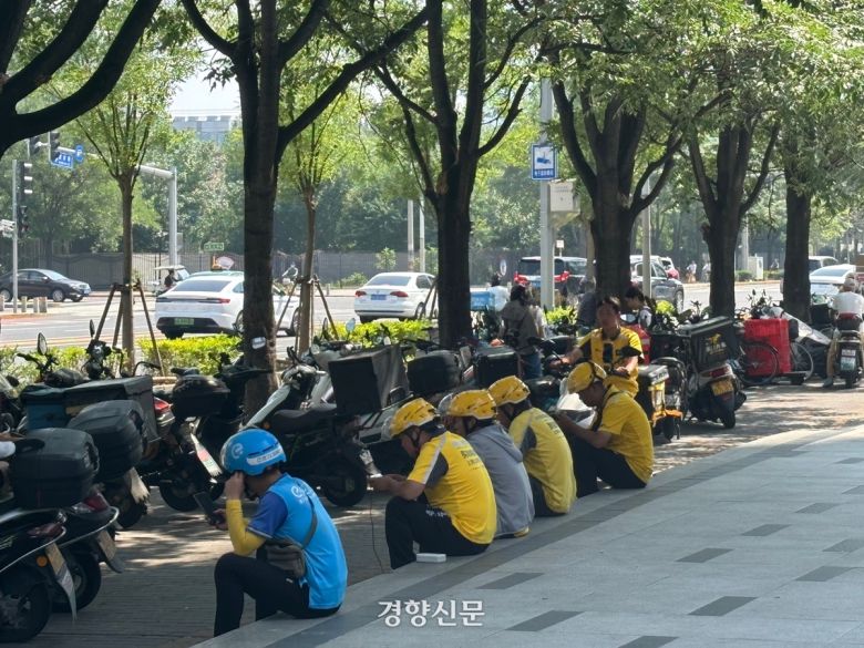 베이징 차오양구의 한 상가 앞에서 여러 플랫폼의 배달기사들이 앉아서 기주문을 기다리고 있다. /박은하 기자
