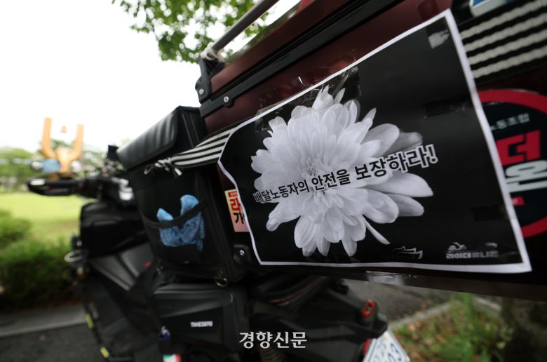 기자회견의 참석한 배달노동자의 오토바이에 배달노동자의 안전을 촉구하는 문구가 부착되어 있다.