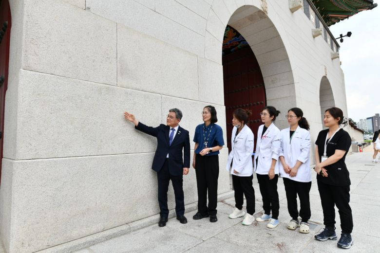허민 국가유산청장(맨 왼쪽)이 지난 11일 서울 경복궁광화문 석축에서 낙서 제거 작업이 완료된 현장을 국립고궁박물관 유물과학과 보존처리팀 관계자들과 확인하고 있다.   국가유산청 제공