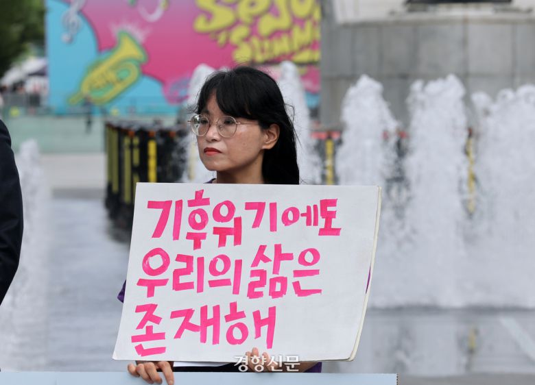 청소년·시민·아기기후소송과 탄소중립기본계획소송 청구인단 및 변호인단 소속 한 활동가가  27일 서울 광화문 이순신 동상 앞에서 열린 기후 헌법소원 결정 1주년 기자회견에서 손피켓을 들고 있다. 2025.08.27. 정지윤 선임기자