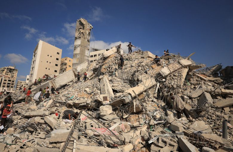 6일 이스라엘군의 공습으로 무너진 건물에서 팔레스타인인들이 현장을 둘러보고 있다. 로이터연합뉴스