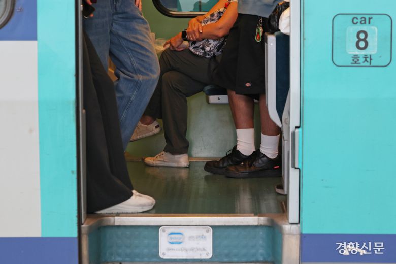 출발하는 기차 안에 사람들이 서 있다.