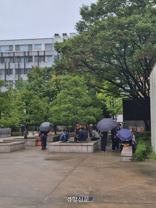 지난 10월 13일 서울 종로구 종묘광장공원에서 노인들이 우산을 쓰고 바둑을 두고 있다. 김향미 기자