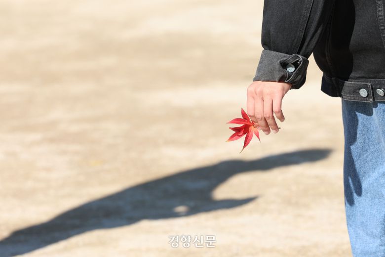 한 시민이 단풍잎을 손에 쥐고 있다.