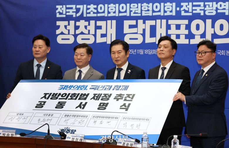 정청래 더불어민주당 대표(가운데), 조승래 사무총장(오른쪽 두 번째)과 참석자 대표들이 18일 국회에서 열린 당대표-전국기초·광역의회의원협의회 간담회에서 공동서명식을 하고 있다. 박민규 선임기자