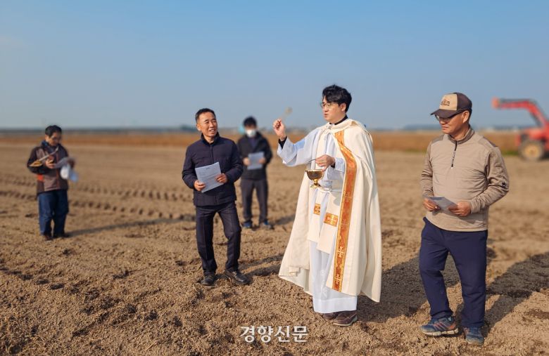 유정현 신부가 13일 밀밭축복식에서 성수를 뿌리고 있다.