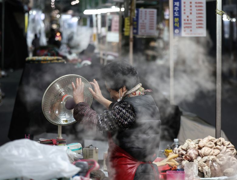 3일 대구 중구 서문시장에서 한 상인이 장사 준비를 하며 빨갛게 언 손을 난방기에 녹이고 있다. 연합뉴스