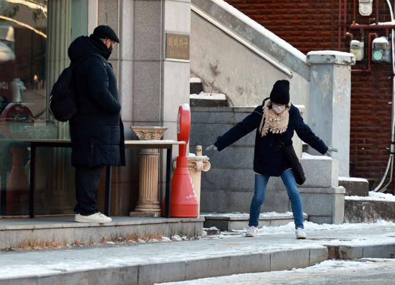 폭설 후 한파로 도로 곳곳이 얼어붙은 5일 서울 이태원역 인근에서 외국인들이 빙판길을 조심히 걷고 있다. 연합뉴스