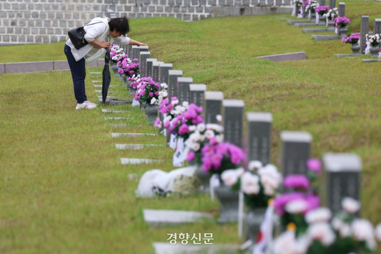 5·18 민주화운동 45주기를 사흘 앞둔 지난 5월 15일 광주 북구 국립 5·18 민주묘지를 찾은 참배객이 이요승씨의 묘비를 쓰다듬고 있다. 정효진 기자