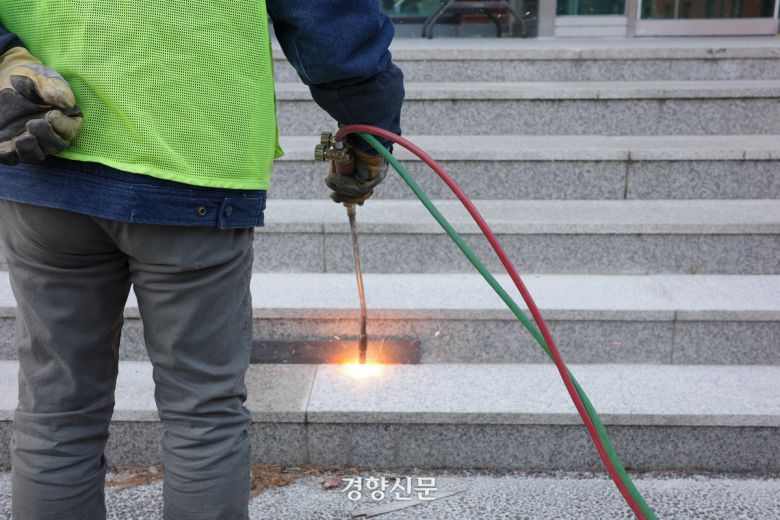 지난 14일 경기 수원시의 한 교회 앞에서 강윤규씨(57)가 화염 토치로 돌계단을 향해 불을 쏘고 있다. 우혜림 기자