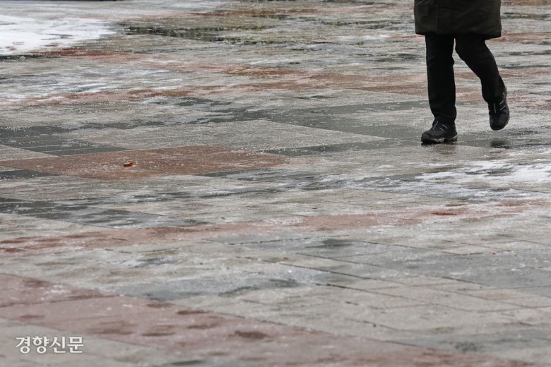 19일 전날 내린 눈으로 길이 얼어있다. 서울 종로구 세종대로 사거리에서 한 시민이 조심하며 출근하고 있다.