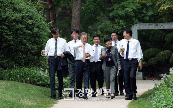 문재인 대통령 취임 사흘째인 2017년 5월 11일 ,문 대통령이 신임 수석 비서관들과 오찬을 갖은 후 청와대 소공원에서 차담회를 갖기 위해 이동하고 있다. 왼쪽부터 조국 민정수석, 권혁기 춘추관장, 문 대통령, 이정도 총무비서관, 조현옥 인사수석, 송인배 전 더불어민주당 선대위 일정총괄팀장, 윤영찬 홍보수석, 임종석 비서실장. / 청와대사진기자단