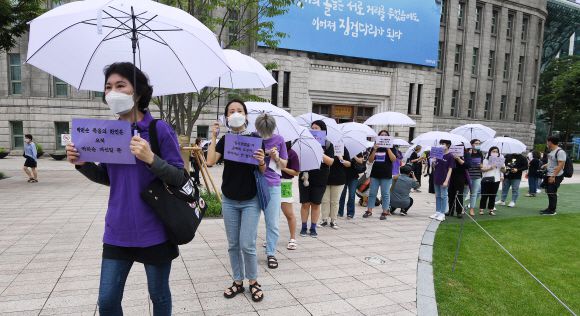 “당신은 혼자가 아닙니다” 보랏빛 연대 - 박원순 전 서울시장을 성추행 혐의로 고소한 피해자를 지원하는 여성단체들이 28일 기자회견을 열고 박 전 시장의 성추행 의혹 등 전반에 대해 국가인권위원회가 직권으로 조사해 달라고 요청했다. 인권위가 적극적으로 개선할 문제를 조사하고 제도 개선 권고를 해 달라는 취지다. 여성단체 활동가와 일반 시민 등 150여명이 여성의 존엄을 상징하는 보라색 우산을 들고 서울시청 광장에서 인권위 앞까지 행진하고 있다. 오장환 기자 5zzang@seoul.co.kr