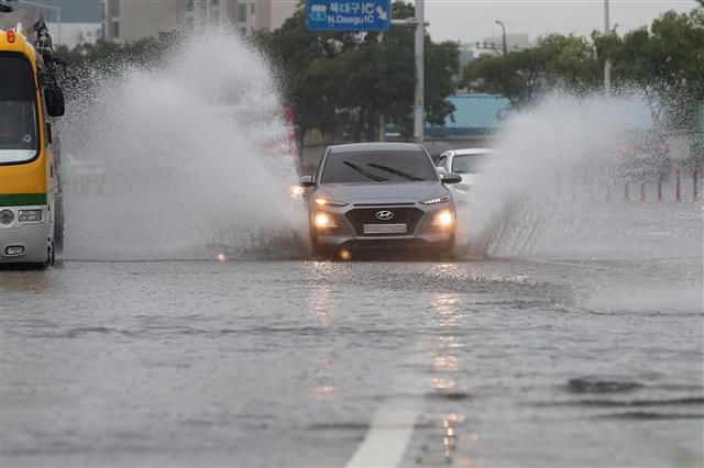대구 폭우 - 대구와 경북 일부 지역에 내려진 호우특보가 호우경보로 확대된 7일 오후 대구 북구 신천동로 무태교 인근 도로가 일부 침수돼 차량이 물보라를 일으키며 달리고 있다. 2020.8.7/뉴스1