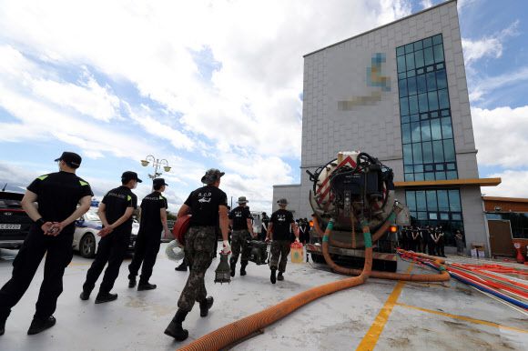 납골당 침수, 배수작업 지원하는 군 - 최근 폭우로 침수 피해가 난 광주 북구 동림동 한 사설 납골당에서 9일 군 관계자가 배수 작업을 지원하고자 장비를 들고 이동하고 있다. 2020.8.9 연합뉴스