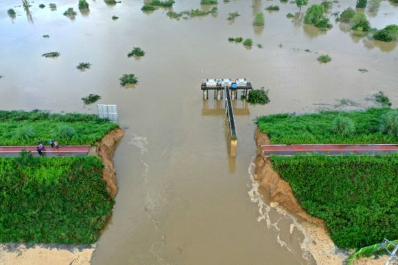 뚝 끊긴 낙동강 제방  - 9일 경남 창녕군 이방면에서 낙동강 제방 40~50m가 유실되면서 물길이 인근 마을로 향하고 있다. 전날 최대 450㎜의 폭우로 제방이 무너진 이방면은 장천리 구학마을과 죽전마을 등 2곳이 물에 잠기면서 주민 156명이 인근 학교로 대피하는 등의 피해를 입었다.창녕 연합뉴스