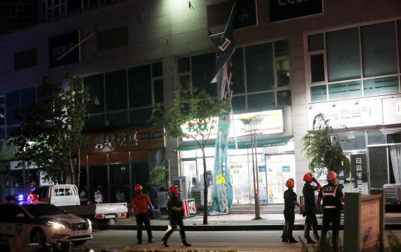 제8호 태풍 ‘바비’가 북상한 26일 오후 전남 목포시에서 건물 외벽의 현수막이 강풍에 찢겨 119 구조대가 안전조치하고 있다. 연합뉴스.