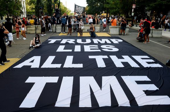 도널드 트럼프 미국 대통령의 대선 후보 수락 연설을 3시간 정도 앞둔 27일(현지시간) 오후 백악관으로 이어지는 워싱턴 DC 도로에도 벌써 ‘흑인목숨도소중해(BLM)’ 시위대가 몰려와 ‘트럼프는 늘상 거짓말을 한다’ 플래카드를 도로에 깐 채 구호를 외치고 있다.워싱턴 DC AFP 연합뉴스