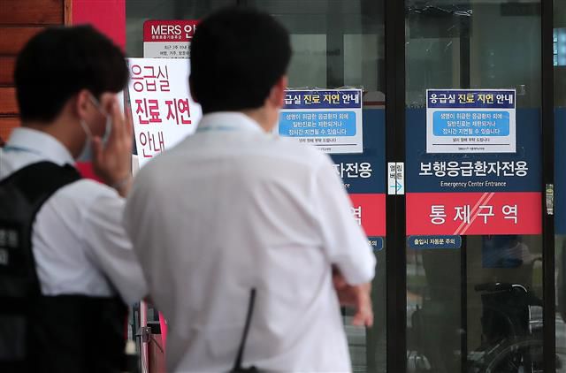 응급실에 붙은 진료 지연 안내문 - 30일 서울 종로구 서울대병원 응급실 출입구에 진료 지연 안내문이 게시돼 있다. 서울대병원은 오는 31일부터 소화기?순환기?신장?혈액종양?호흡기내과 등 9개 내과 분과의 외래진료를 축소한다. 전공의와 전임의(임상강사)들의 파업으로 교수들의 진료부담이 과중해진데 따른 조치다. 2020.8.30 뉴스1