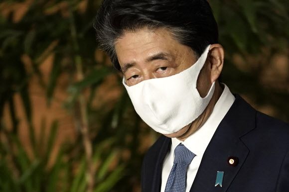 어두운 낯빛의 아베 신조 일본 총리가 28일 전격 사임을 발표한 총리 관저 기자회견 직후 마스크를 쓰고 퇴장하고 있다.도쿄 AP 연합뉴스