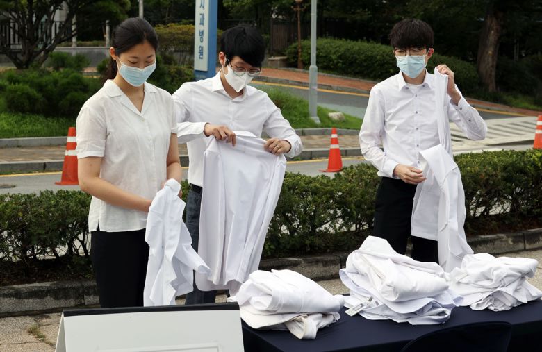 - 사진은 지난 23일 서울 종로구 서울대병원 본관 앞에서 의과대학·의학전문대학원 정원 증대 등 정부의 공공의료 확대 정책에 반대하는 전공의들이 의사 가운을 탈의하고 있는 모습. 2020.8.23 연합뉴스