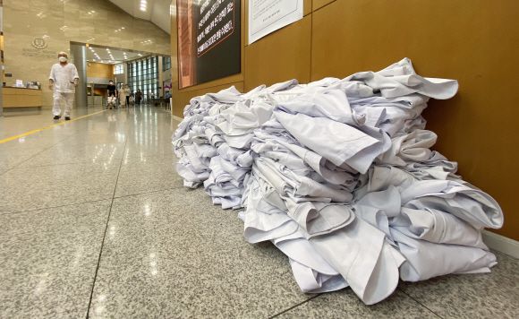 23일 서울 서대문구 신촌세브란스병원 로비 벽 앞에 전공의들이 벗어 놓은 의사 가운이 쌓여 있다. 오장환 기자 5zzang@seoul.co.kr